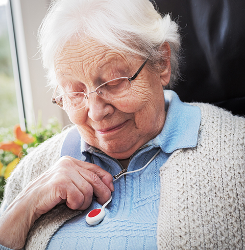 Elderly woman looking at her medical alert device